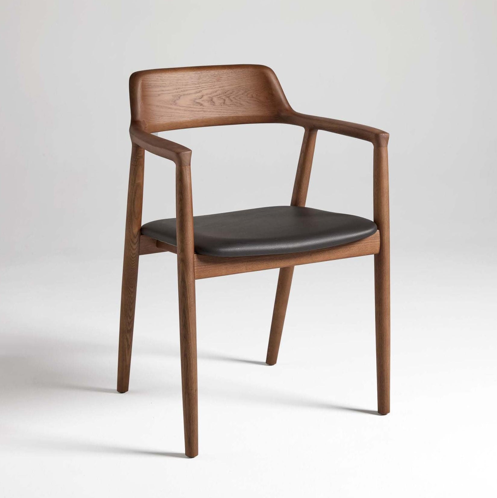 A dining chair with a solid ash wood frame and faux leather upholstery on the seat.