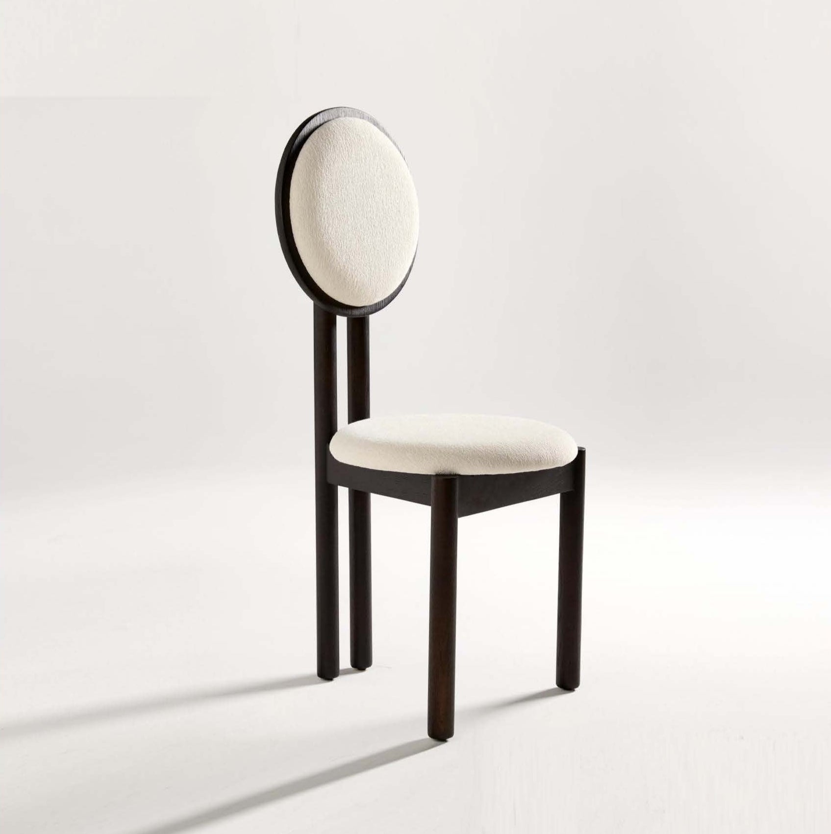 A modern dining chair with a solid ash wood frame and a round upholstered backrest in a neutral color.