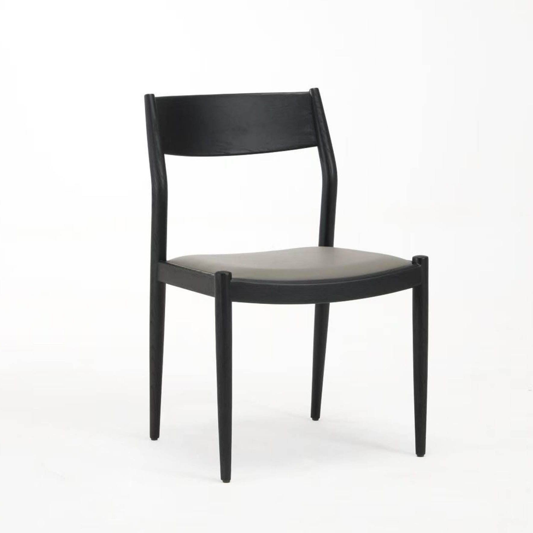 A black dining chair with a solid ash wood frame and faux leather upholstery.