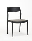A black dining chair with a solid ash wood frame and faux leather upholstery.