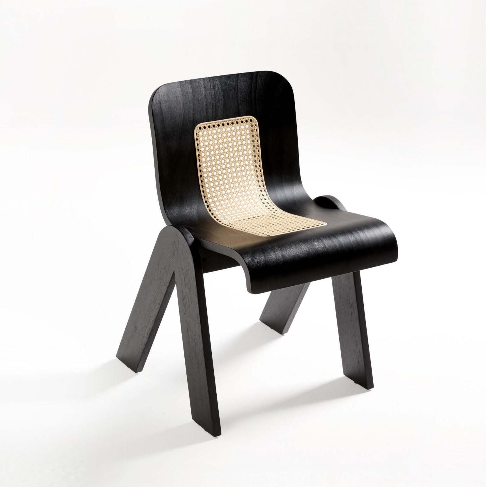 A black dining chair with a solid rubber wood frame and a seat made of rattan.
