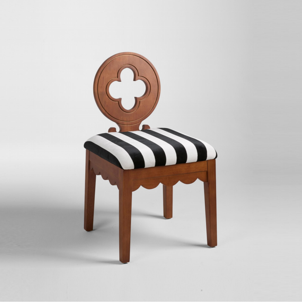 A dining chair with a solid rubber wood frame and a black and white striped seat upholstery, known as the Molly Dining Chair.