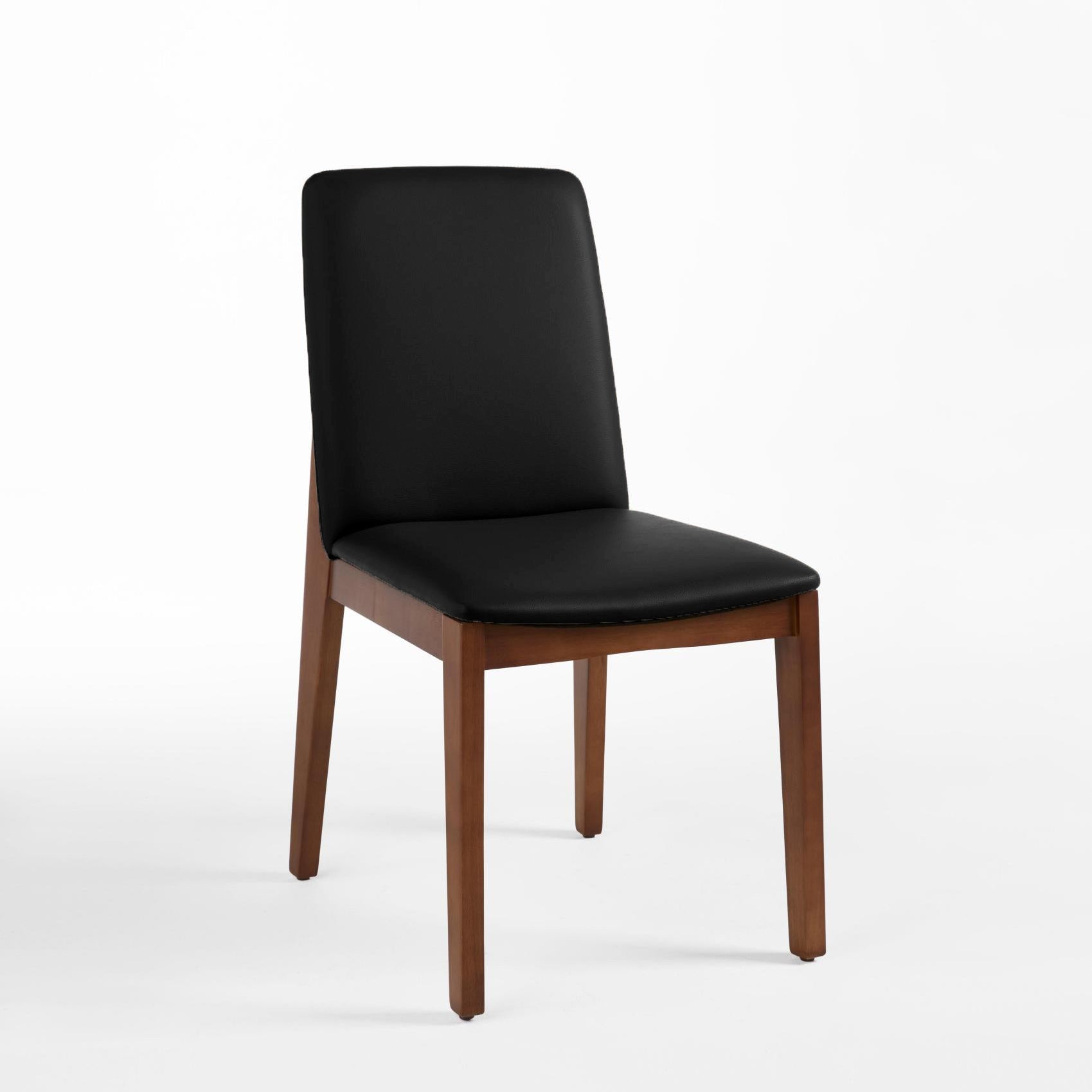 A black faux leather upholstered dining chair with a solid rubber wood frame.