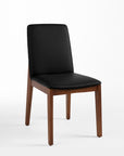 A black faux leather upholstered dining chair with a solid rubber wood frame.