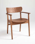 A brown dining chair made of solid ash wood, with a full back and armrests.